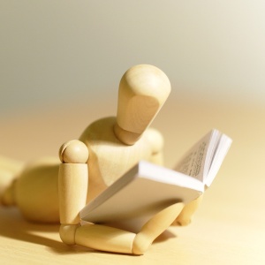 Manequin en bois en position de lecture
